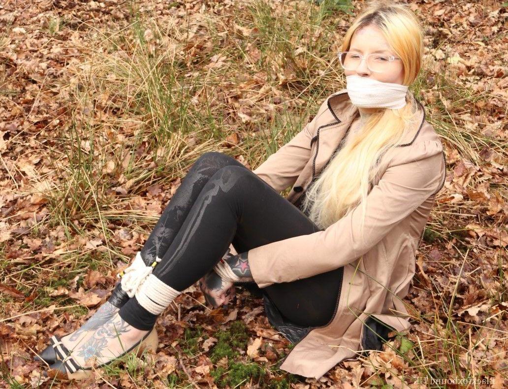 16P Bekleidete Frau wird im Wald geknebelt an Handgelenken und Knöcheln gefesselt