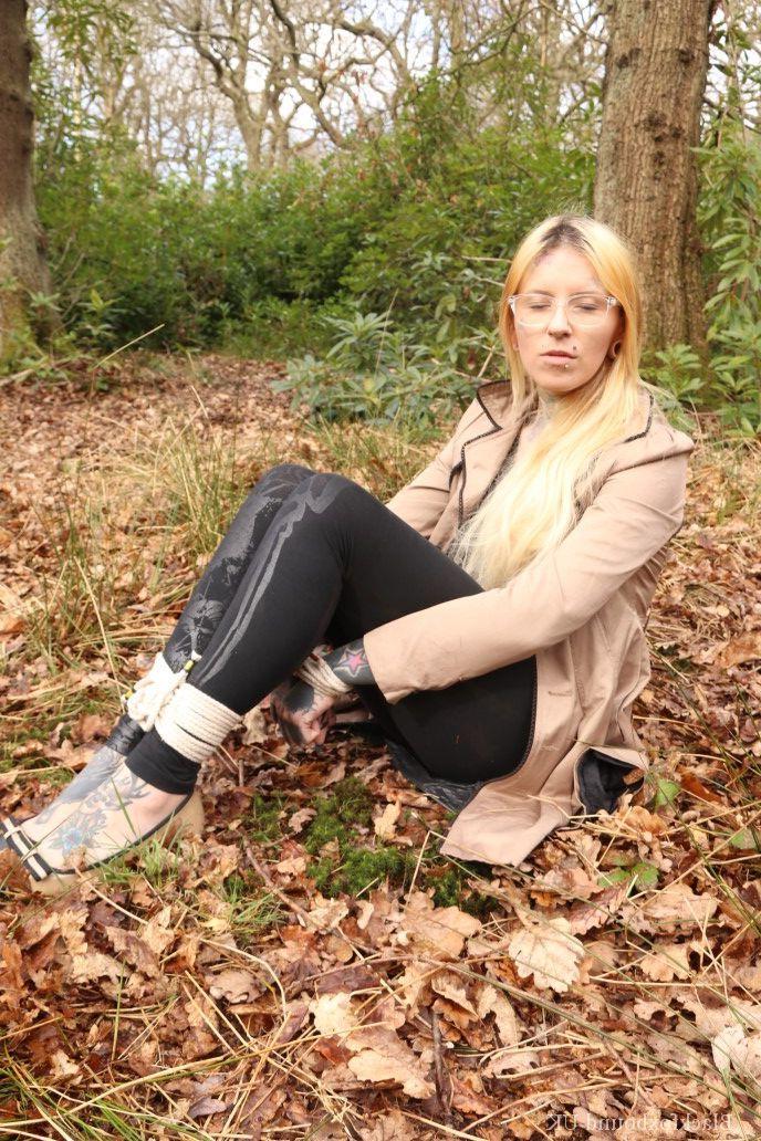 16P Bekleidete Frau wird im Wald geknebelt an Handgelenken und Knöcheln gefesselt