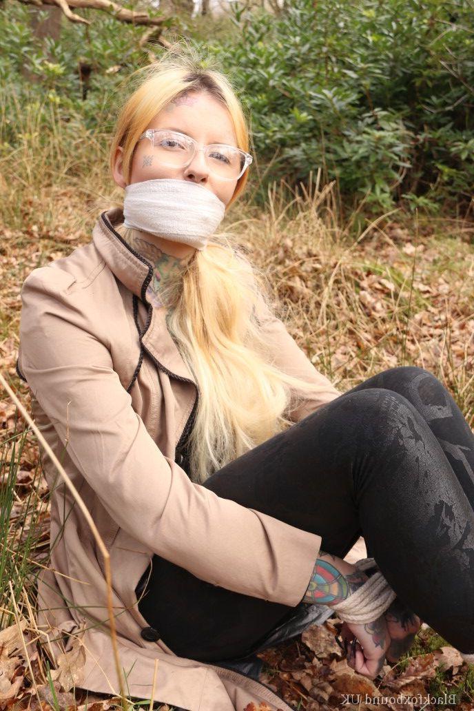 16P Bekleidete Frau wird im Wald geknebelt an Handgelenken und Knöcheln gefesselt