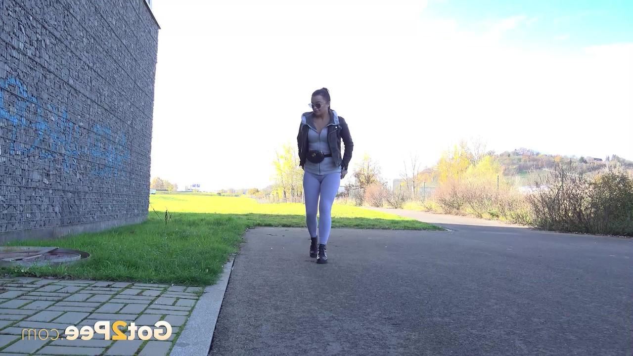 15P A garota sozinha Dafne faz xixi na calçada enquanto usa óculos escuros e botas