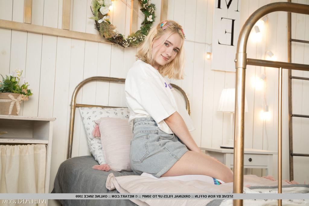 18P La charmante jeune blonde Stevie se met nue sur un lit simple.