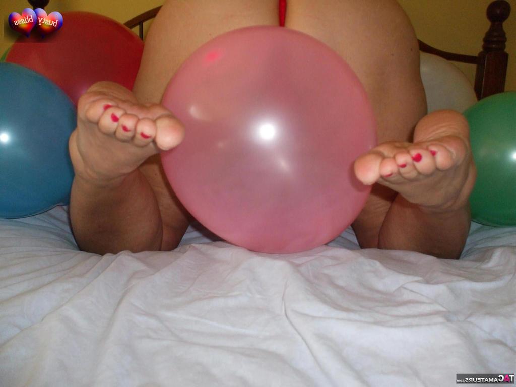 20P Busty Bliss, femme mûre, se met seins nus sur son lit en jouant avec des ballons.