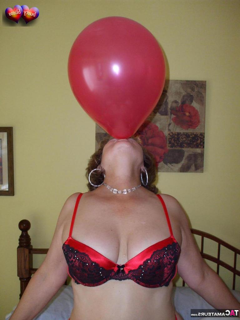 20P Busty Bliss, femme mûre, se met seins nus sur son lit en jouant avec des ballons.