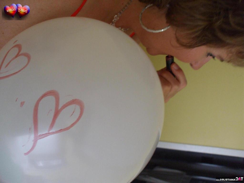 20P Busty Bliss, femme mûre, se met seins nus sur son lit en jouant avec des ballons.