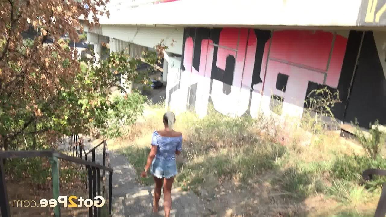 15P La rubia natural julia parker mea mientras desciende unos escalones de hormigón