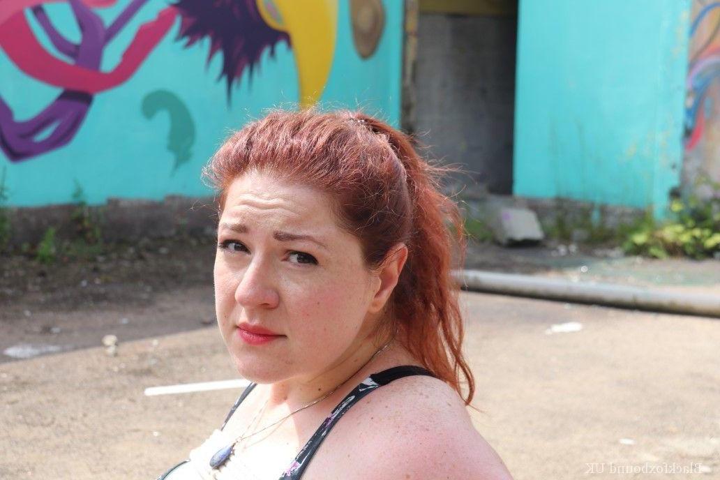 16P Redheaded girl Mada Rose is left on a paved lot while tied up