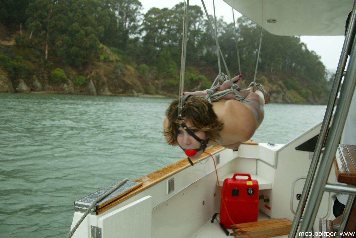 12P Kat, une jeune coquine au cul naturel, est attachée avec une corde et suspendue sur un bateau.