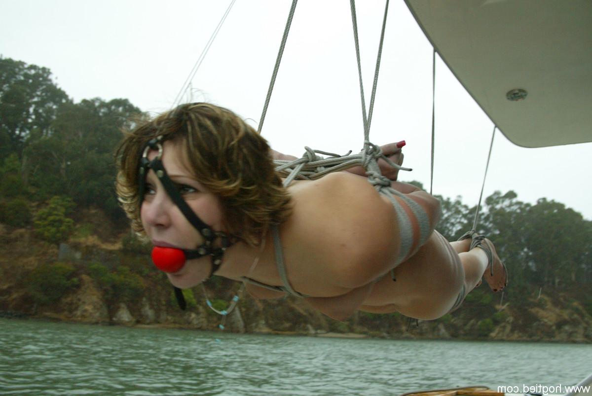 12P Kat, une jeune coquine au cul naturel, est attachée avec une corde et suspendue sur un bateau.