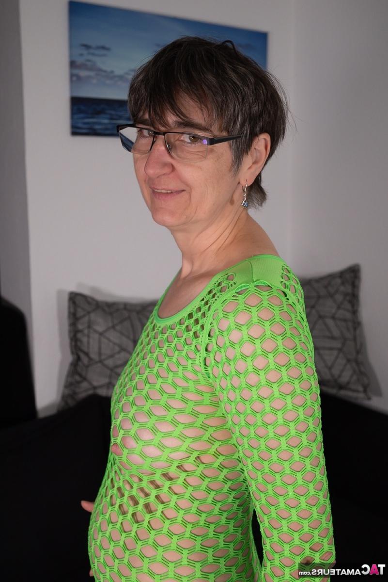 16P Old lady slides a purple dildo inside her hairless pussy while wearing glasses