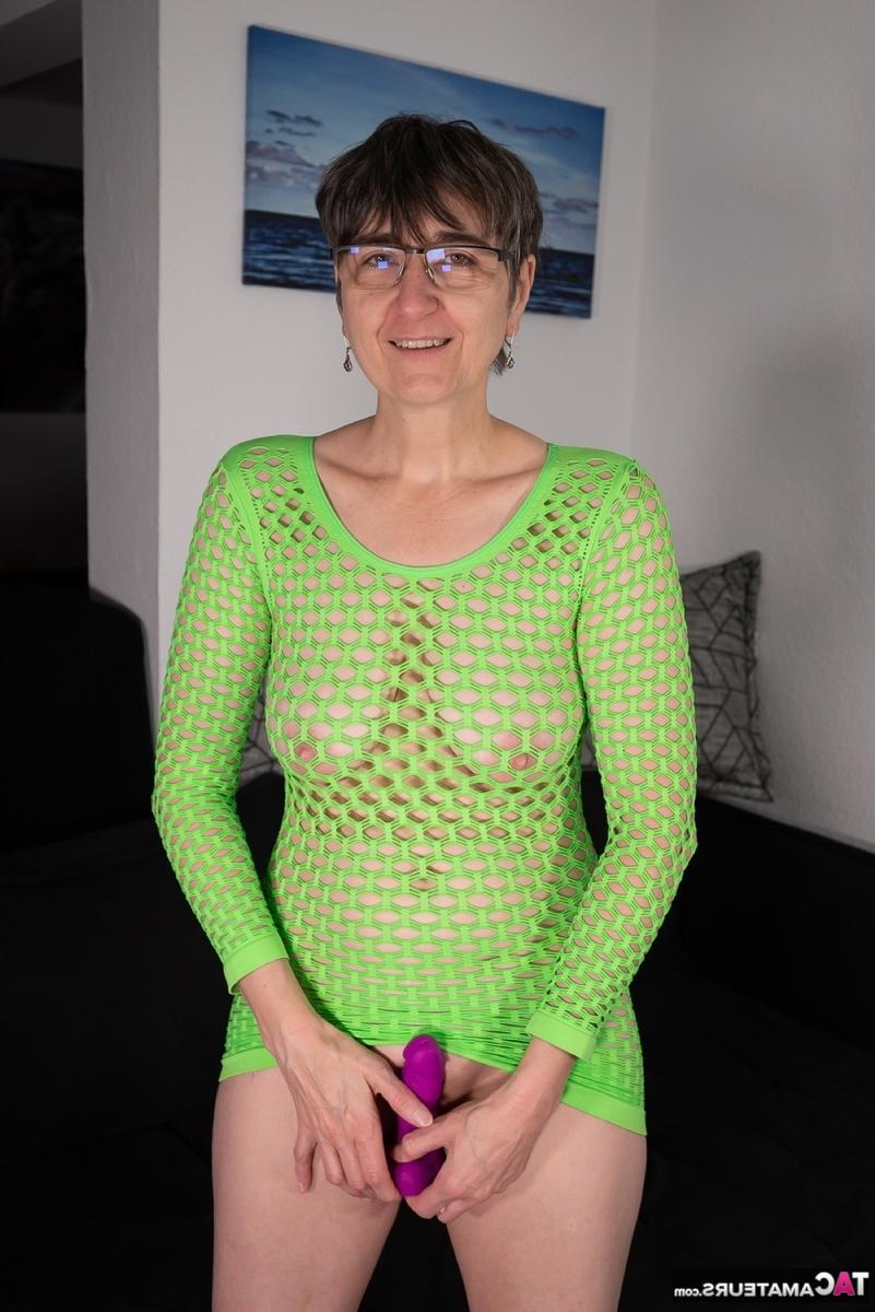 16P Old lady slides a purple dildo inside her hairless pussy while wearing glasses