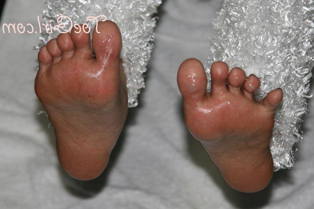 16P Caucasian female spreads her toes whilst sporting an oily sheen