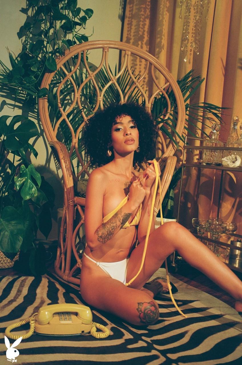 20P Stunning curly haired babe Sunni flaunts her nice juggs and inked body