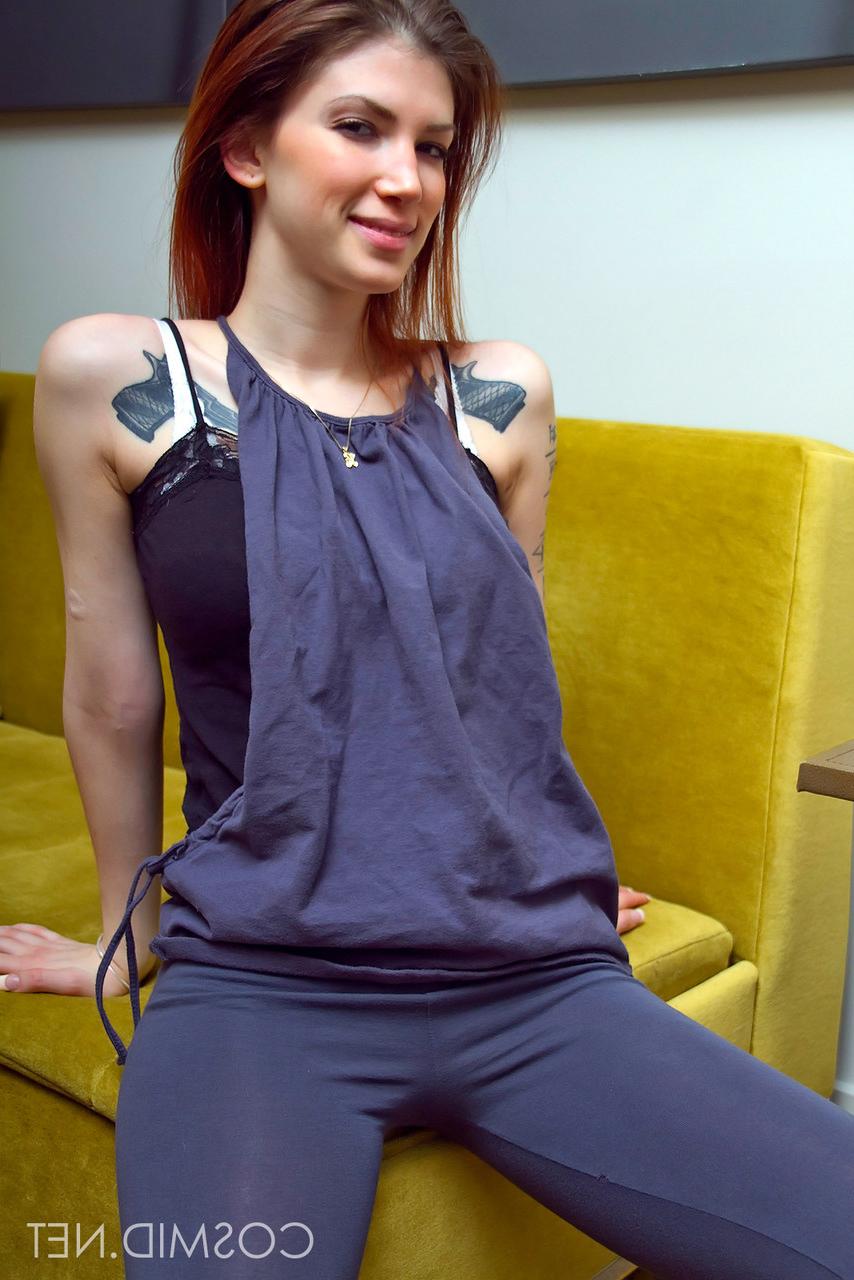 16P Indigo, amateur tatouée, expose ses jolis gros seins et écarte les jambes nues.