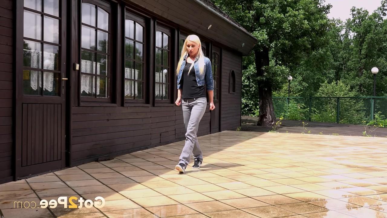 15P Ceca, une blonde, baisse son pantalon pour faire pipi devant un immeuble fermé.