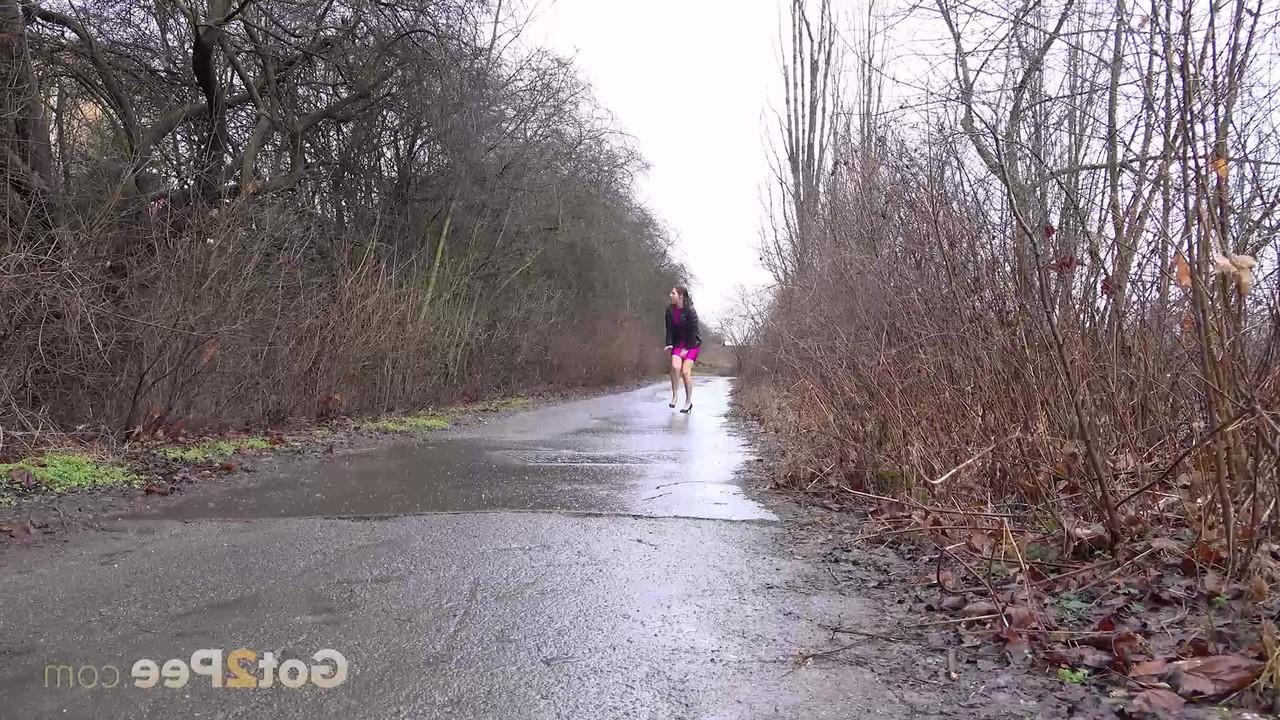 15P Antonia Sainz, une petite fille prise, fait pipi sur une route mouillée avec sa robe relevée