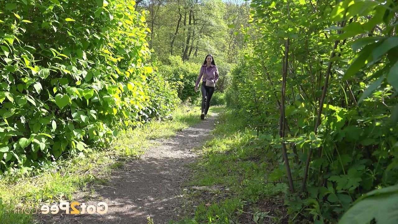 15P Pretty girl Isabel Dark pulls down her pants to pee on a path in the woods