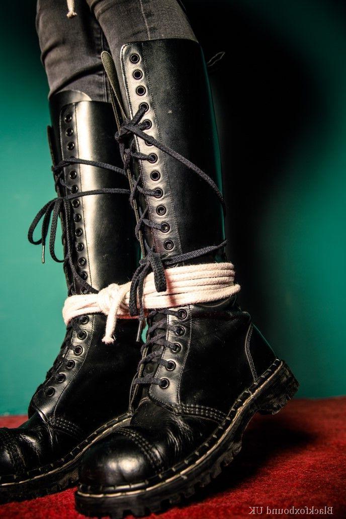 16P Chica pelirroja está amordazada y atada con su ropa y botas de cuero negro.