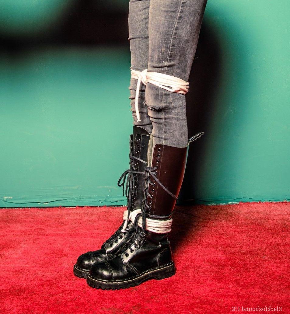 16P Chica pelirroja está amordazada y atada con su ropa y botas de cuero negro.
