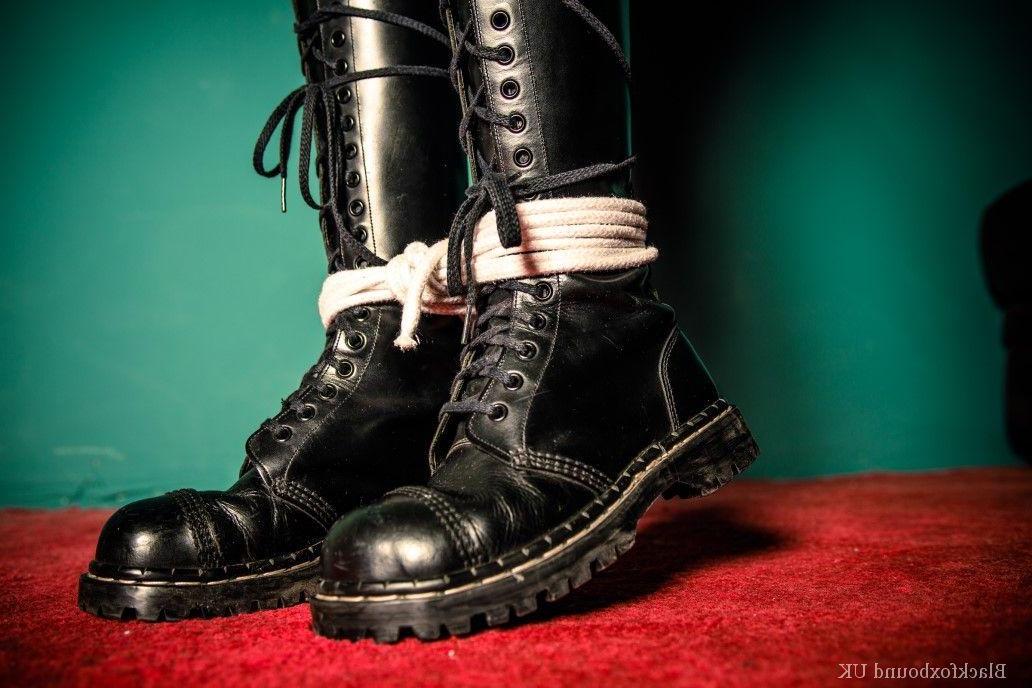 16P Chica pelirroja está amordazada y atada con su ropa y botas de cuero negro.