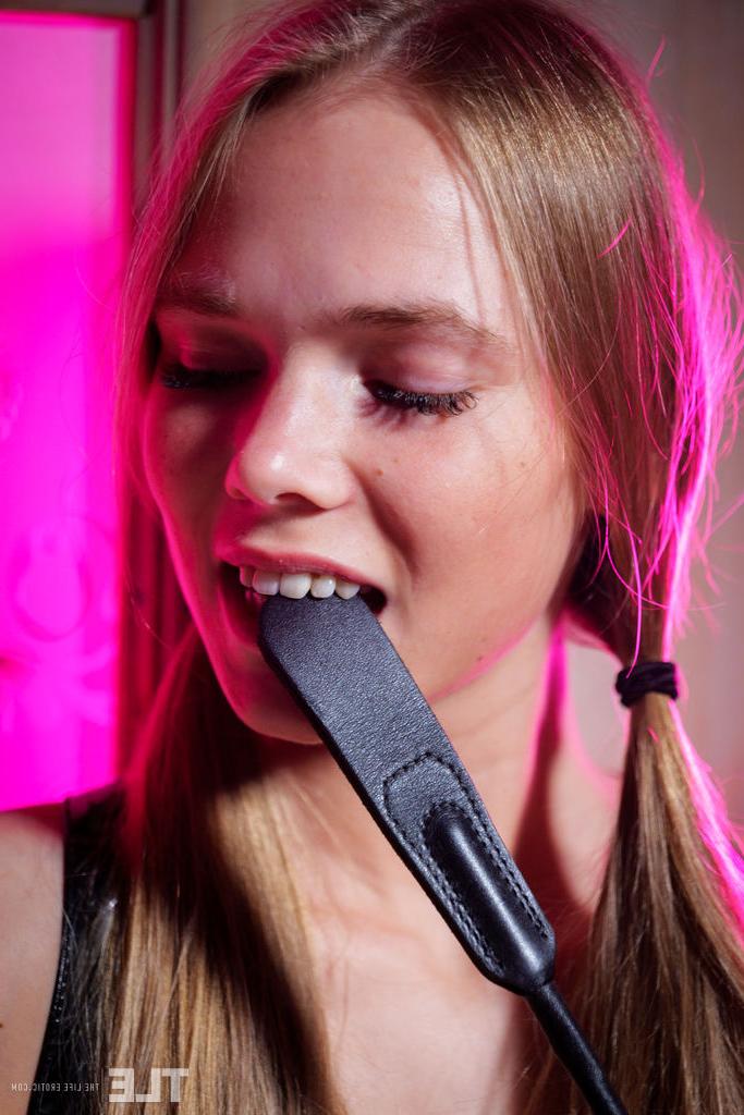 16P Die blonde Teenagerin Luise schwingt eine Gerte, bevor sie ihre haarlose Muschi fingert