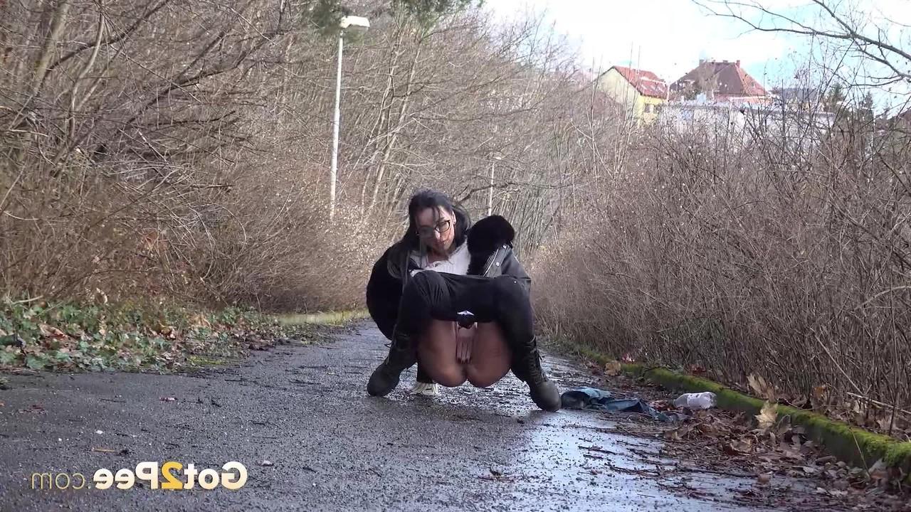 15P La brune Shalina Shine se fait surprendre en train de pisser sur un trottoir mouillé.