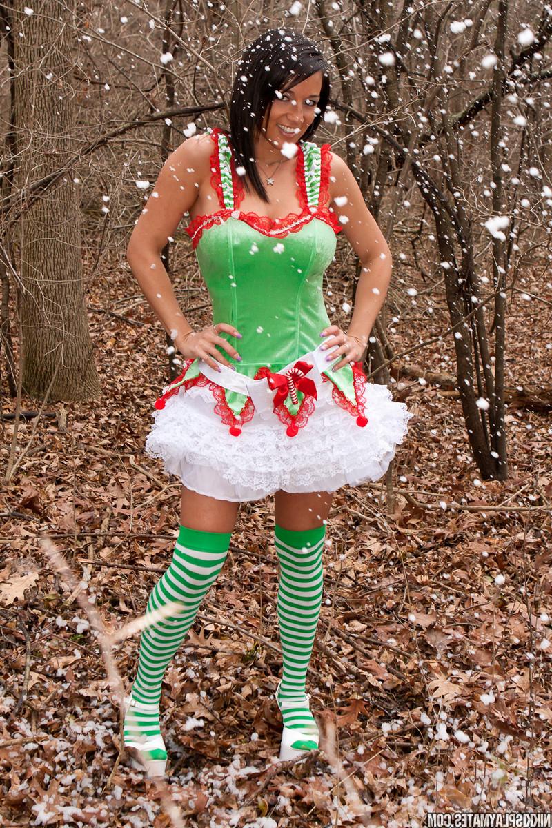 15P A garota amadora Nikki Sims cobre seus seios nus com roupas de Natal em meio à vegetação rasteira