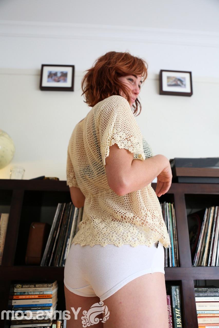 17P Pale redhead Molly Broad strips by the bookcase to flaunt her hairy muff