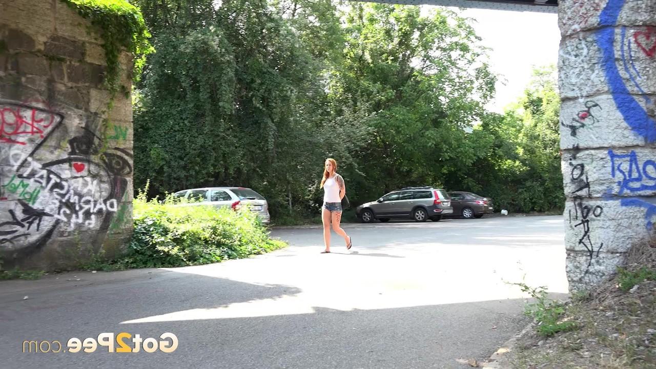 15P Redheaded girl Foxie T takes a pee under an overpass during the day