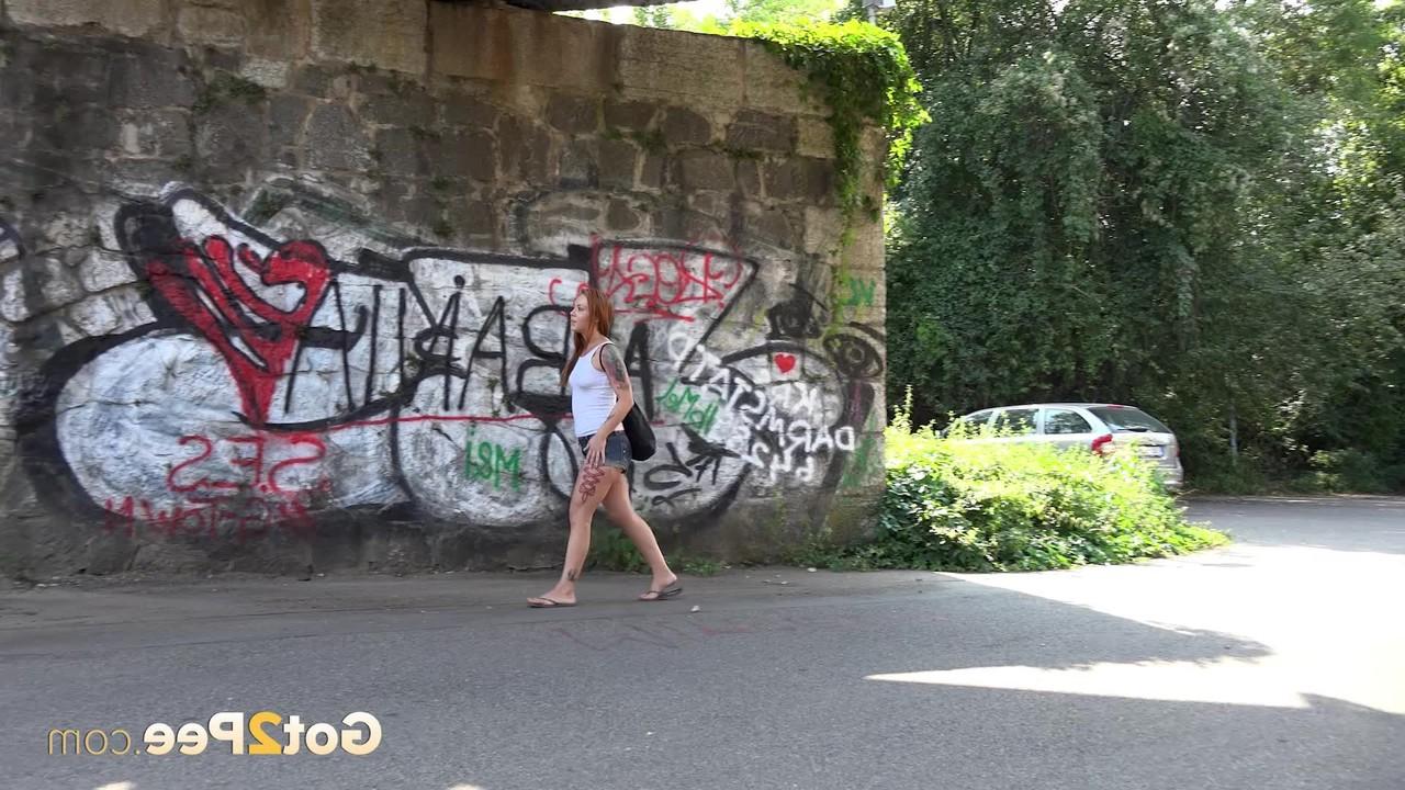 15P Redheaded girl Foxie T takes a pee under an overpass during the day