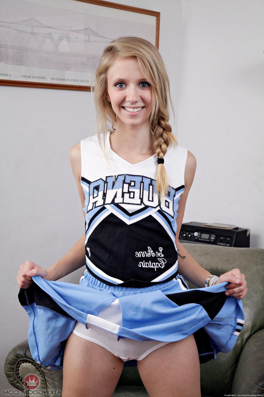 20P Cute cheerleader Rachel James peels off her uniform & spreads her bald cunt