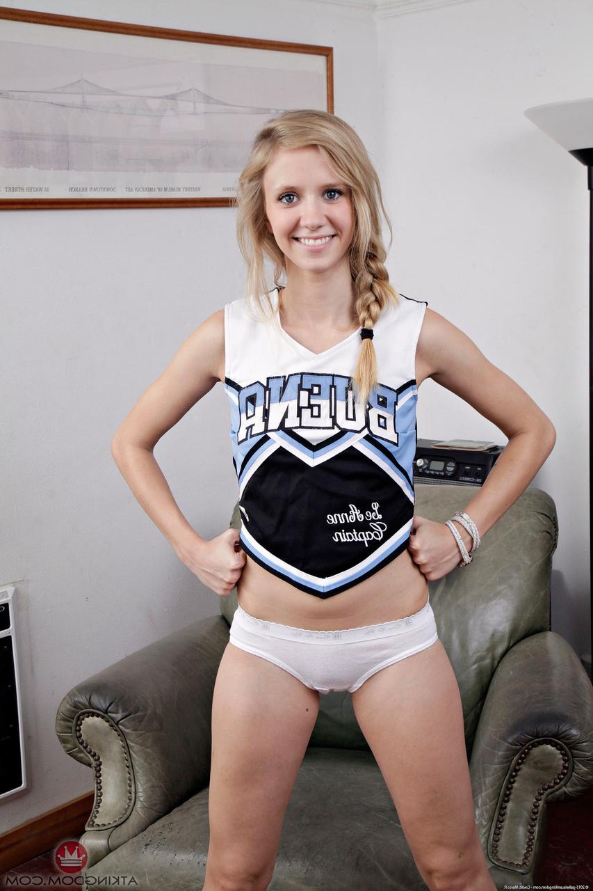20P Cute cheerleader Rachel James peels off her uniform & spreads her bald cunt