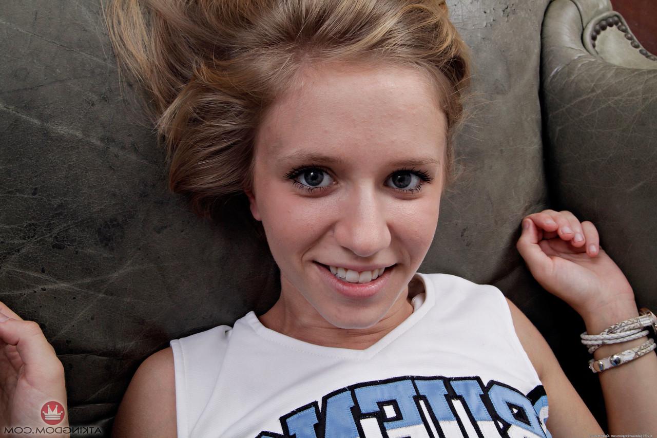 20P Cute cheerleader Rachel James peels off her uniform & spreads her bald cunt