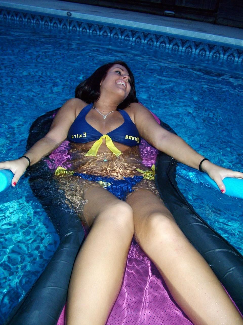 20P Une amatrice brune montre son corps potelé en bikini à la piscine.
