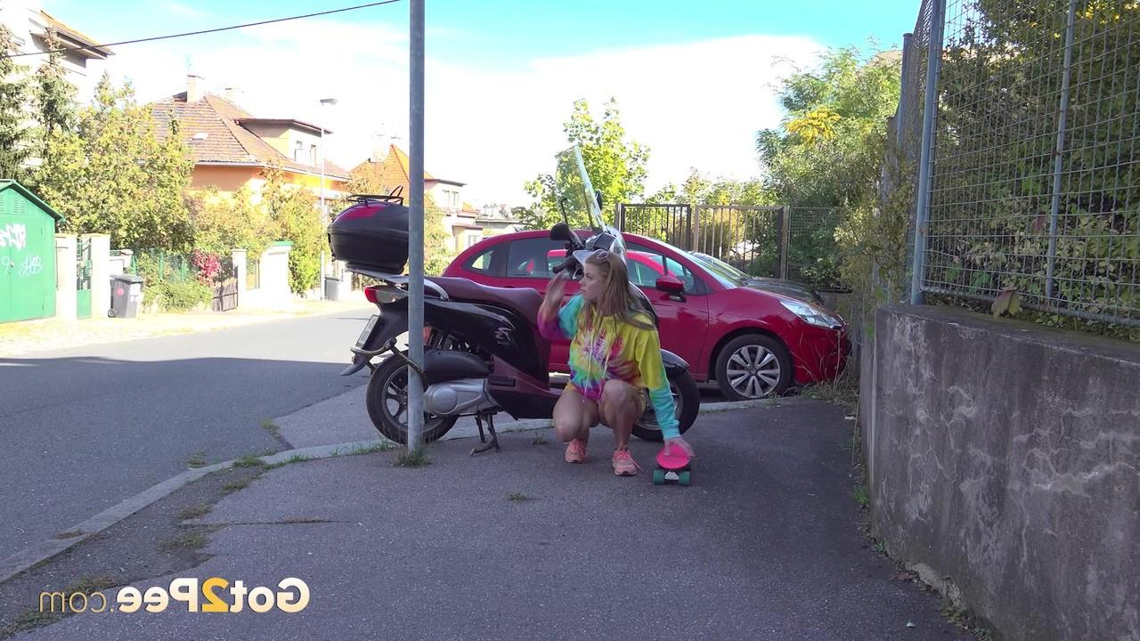 15P La chica blanca Chrissy Fox hace pis en una acera junto a una scooter
