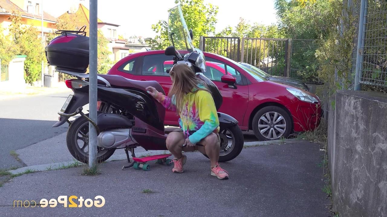 15P La chica blanca Chrissy Fox hace pis en una acera junto a una scooter