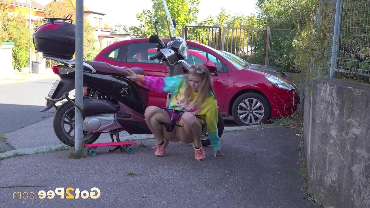 15P La chica blanca Chrissy Fox hace pis en una acera junto a una scooter