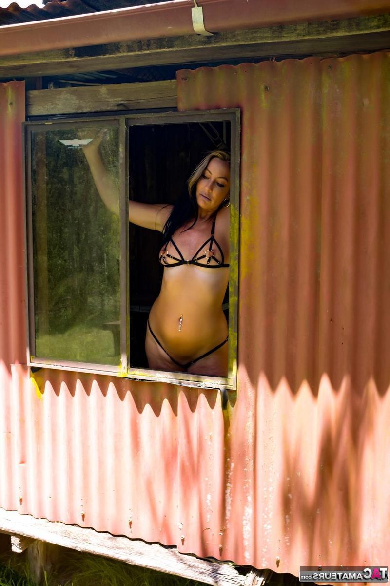 16P Brunette MILF Roxeanne models a revealing bikini in a shack