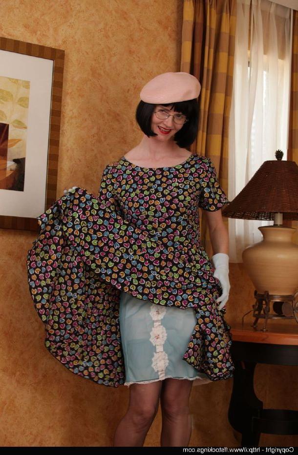 12P Señora madura caliente con gafas quitándose el vestido y posando en lencería