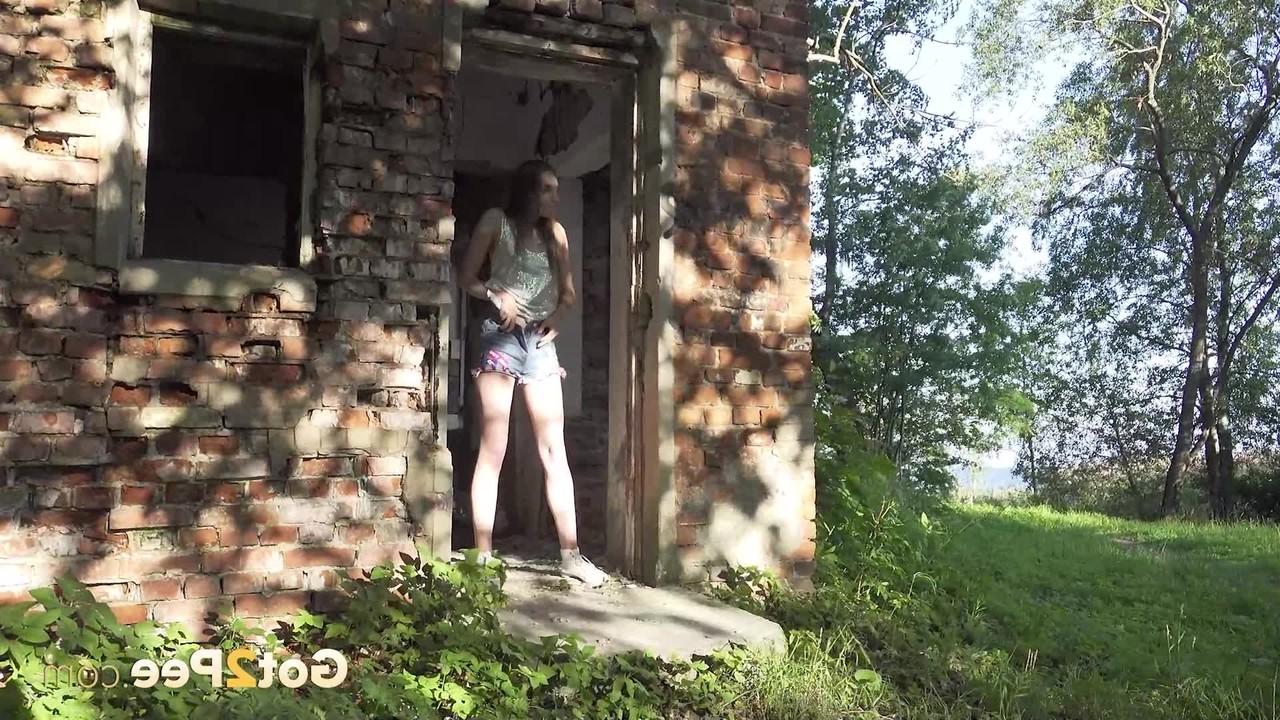 15P Caucasian girl Vika takes a pee in the doorway of an abandoned building
