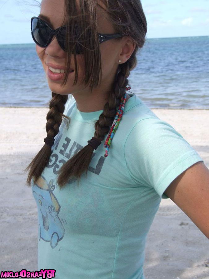 17P Pigtailed teenage darling posing on the beach with so much pleasure