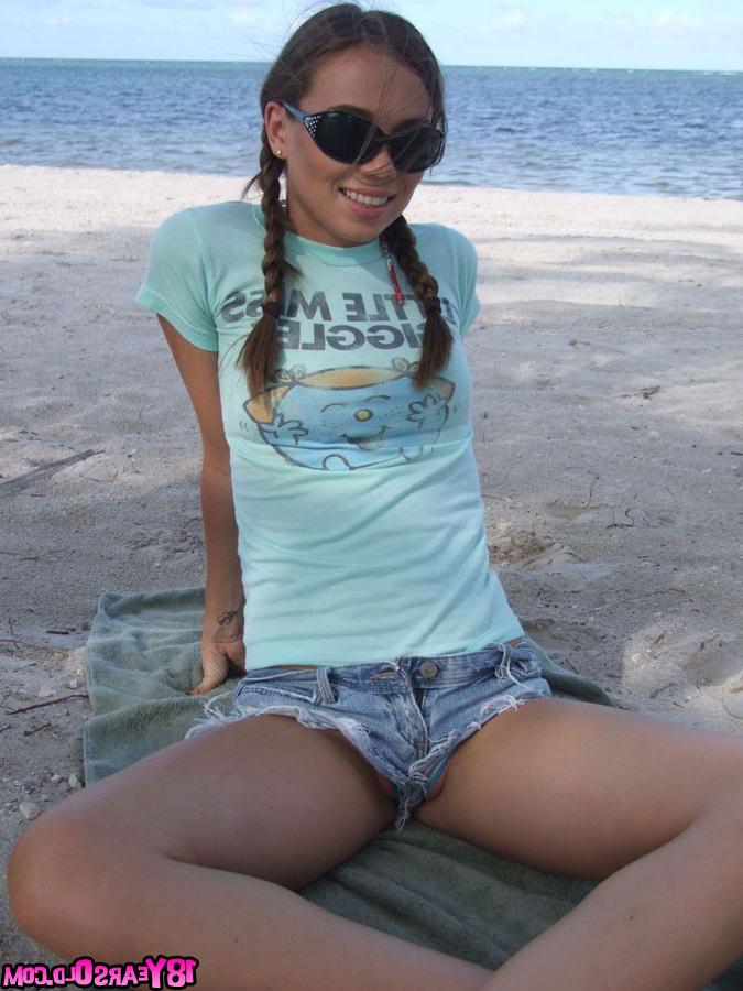 17P Pigtailed teenage darling posing on the beach with so much pleasure