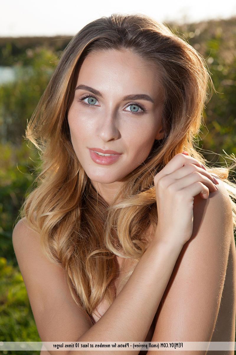 16P La dulce joven Rena muestra sus pechos llenos mientras modela desnuda en un campo