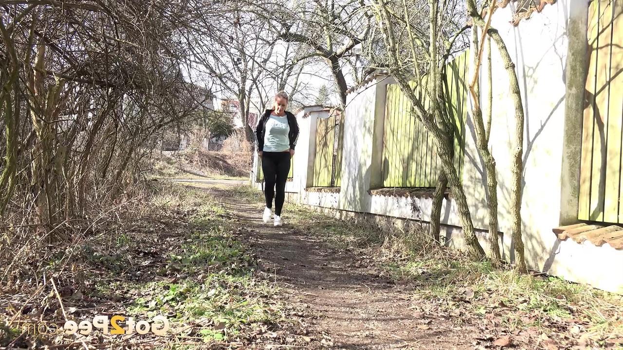 15P Naomi Bennet squats for a badly needed pee on a path behind a building