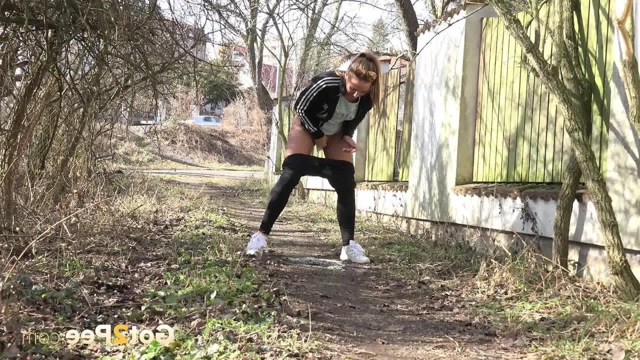 15P Naomi Bennet squats for a badly needed pee on a path behind a building
