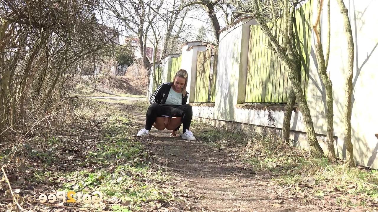 15P Naomi Bennet squats for a badly needed pee on a path behind a building