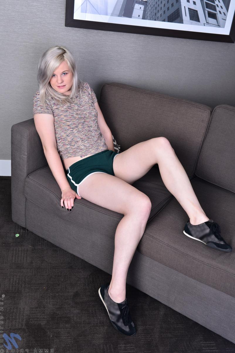 16P Die platinblonde Emma Price zieht sich auf einem Schlafsofa ihre Laufschuhe aus