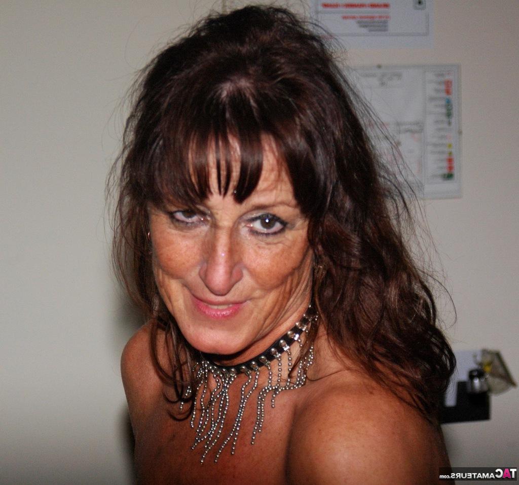 17P Kyra, mature aux cheveux noirs et en chaleur, pose de manière séduisante en latex et en bottes.