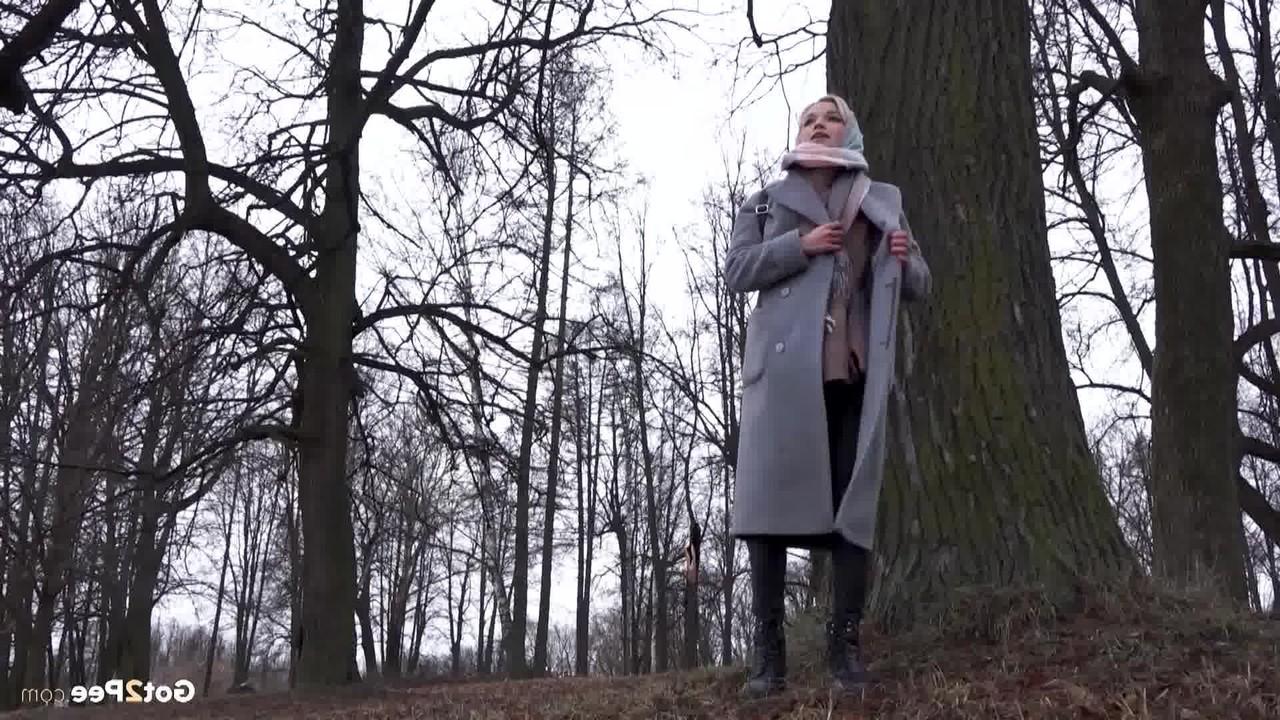 15P Das blonde Mädchen Masha pinkelt an einem kühlen Tag vor einem Baum