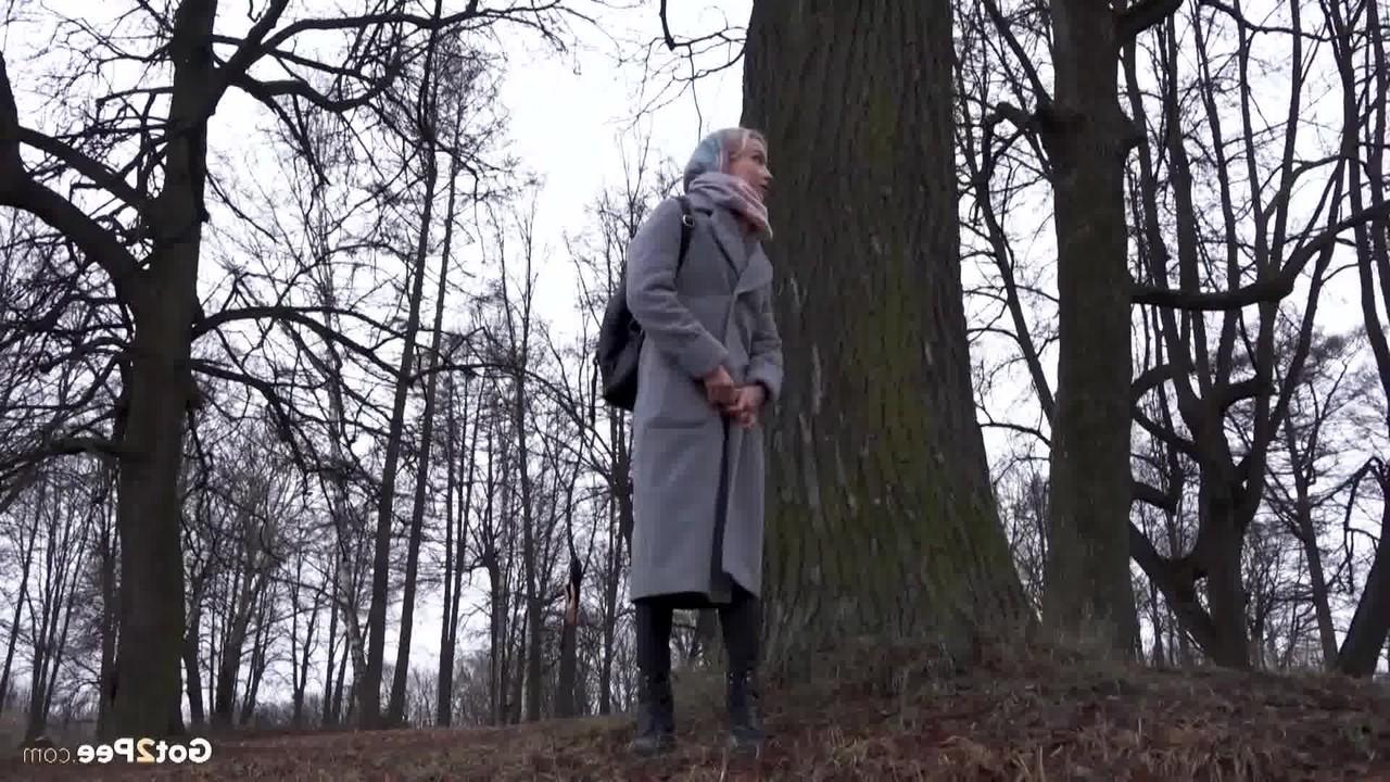 15P Das blonde Mädchen Masha pinkelt an einem kühlen Tag vor einem Baum
