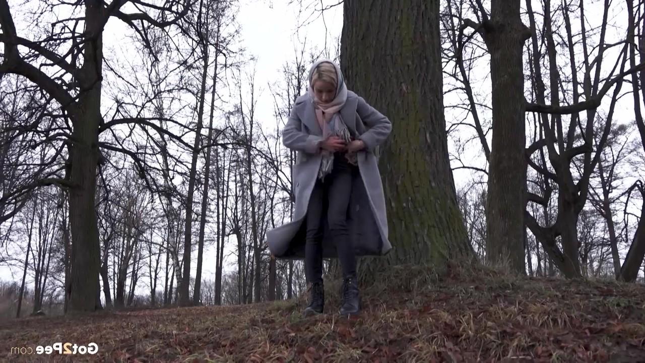 15P Das blonde Mädchen Masha pinkelt an einem kühlen Tag vor einem Baum